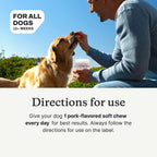Dog being offered a chew by hand; original supplier use illustration